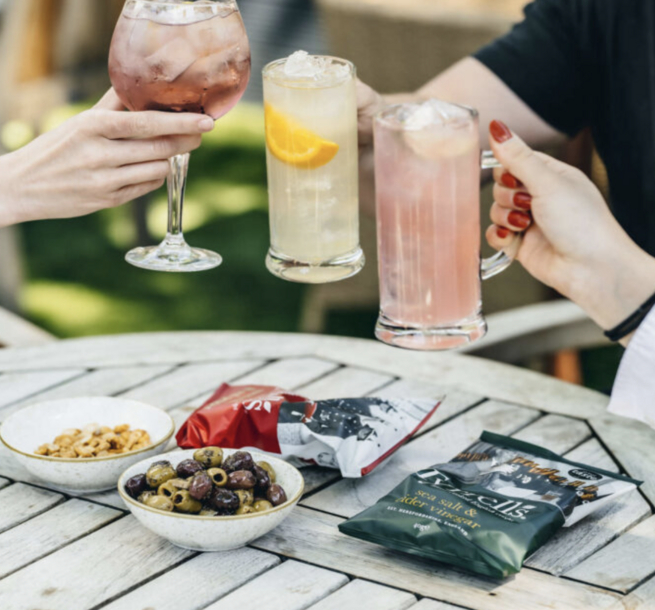 People enjoying cocktails and snacks at Dog & Fox