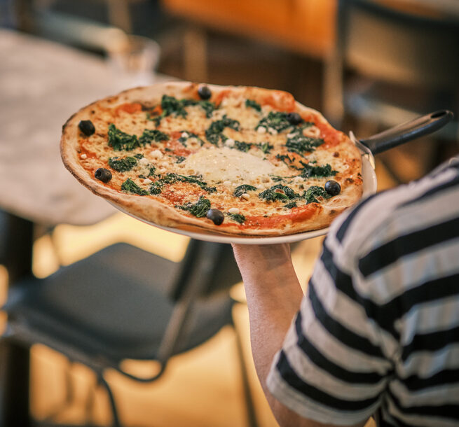 Waiter delivering pizza to customers