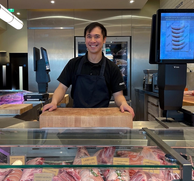 Provenance Village Butcher Assistant Manager standing behind meat counter