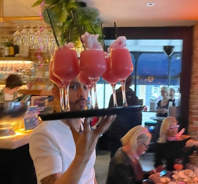 Waiter carrying tray of cocktails at Hemingways