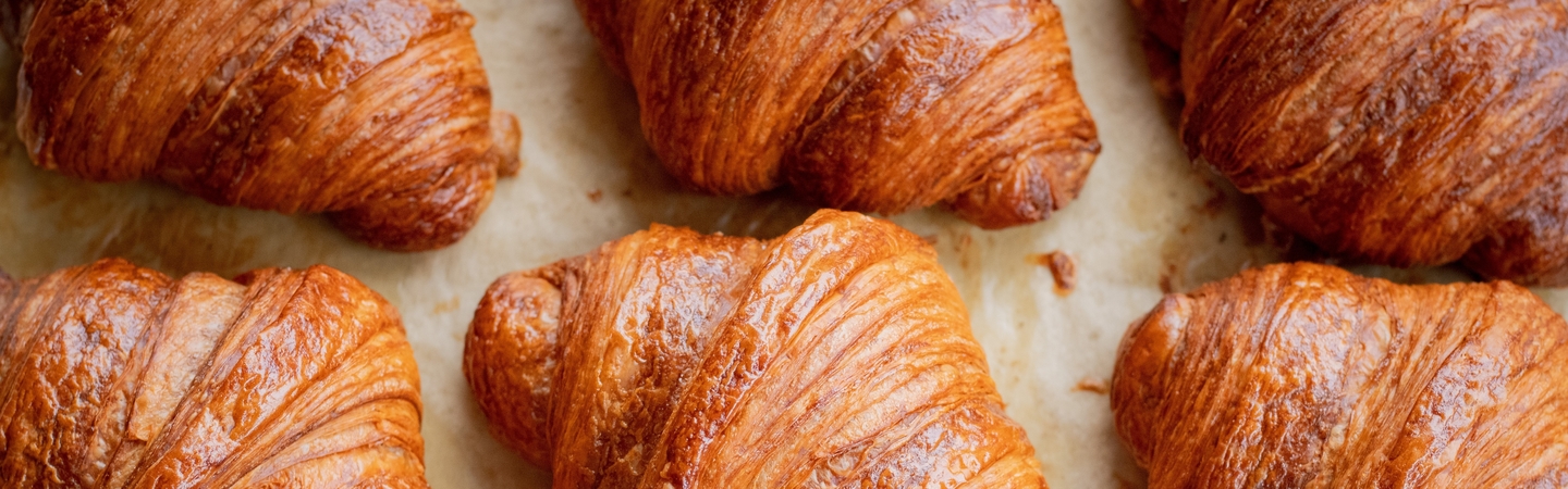 Cafes banner image - rows of fresh-baked croissant