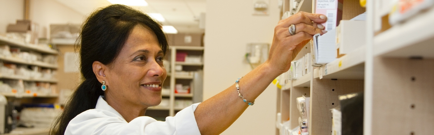 Pharmacies banner image - Pharmacist taking out medications from shelf